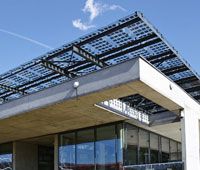 The single story concrete and steel framed building is set into the upper bank of the river Moraca acting as a linear counterpoint to the mast of the landmark Millennium Bridge. The office floor plates float above the ground suspended from an over-sailing concrete slab that serves to replace the ground plane and shades the building and its surroundings from the heat of the summer sun. The building achieves extremely low energy consumption through the combined use of high insulation levels, passive cooling using the concrete structure and day-lighting. The thermal energy for both heating and cooling is drawn from the extensive aquifer underlying Podgorica using a ground source system. The building is topped out with a canopy of Photovoltaic panels with sufficient capacity to supply the building's entire energy needs.